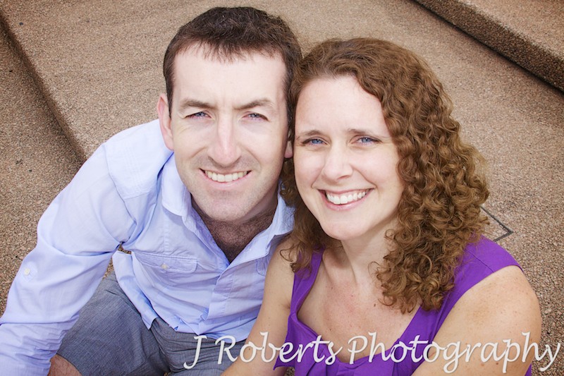 Engaged couple smiling up at the camera - engagement photography sydney